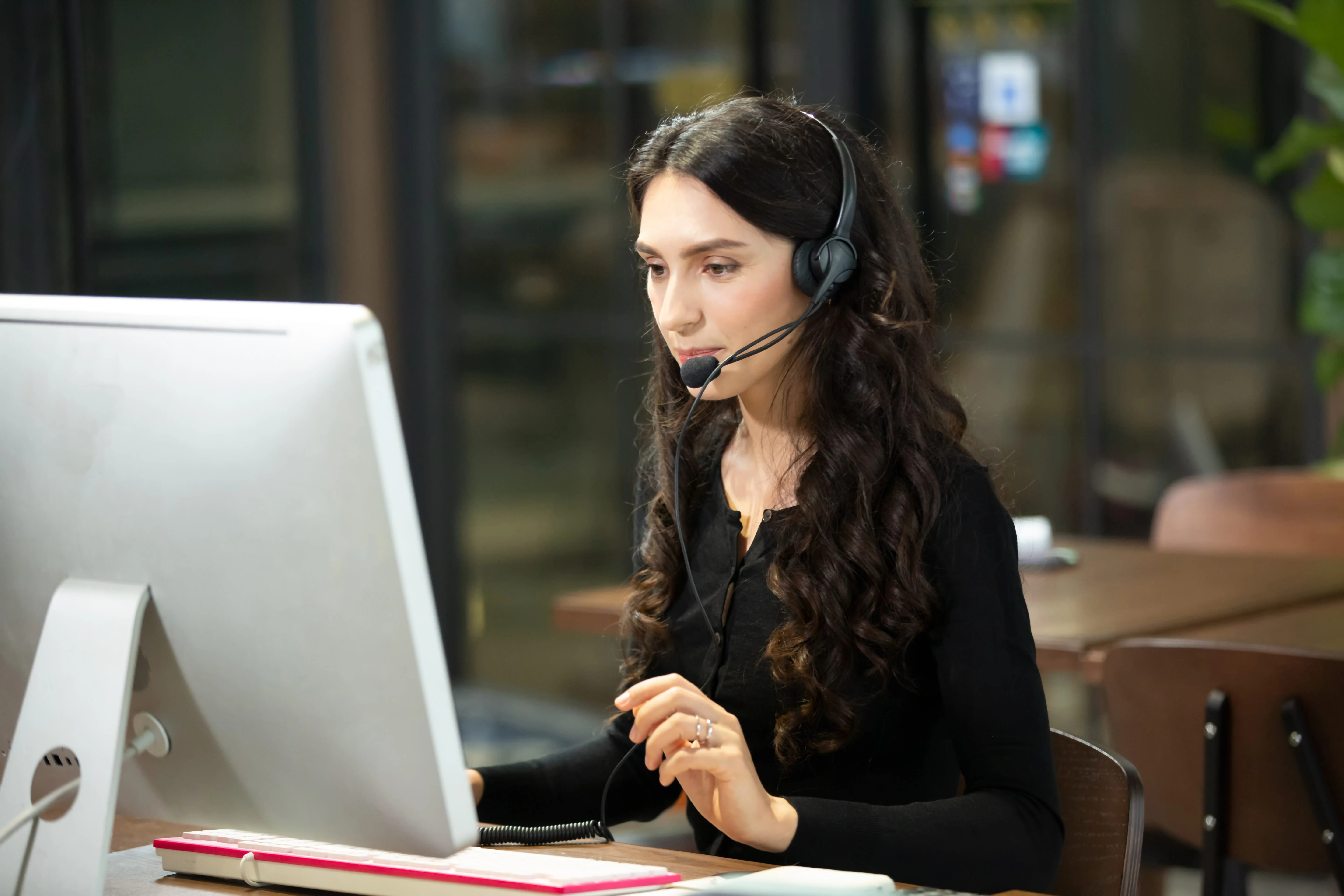 Persona de soporte técnico de GoBus atendiendo una llamada con headset frente a su computadora